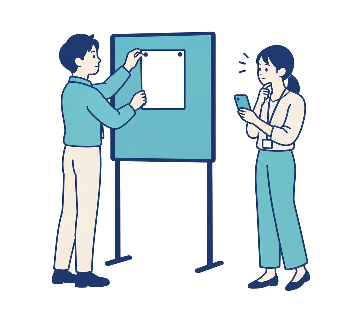 担当者が窓口の案内を掲示し、社員がスマホを手に読んでいる