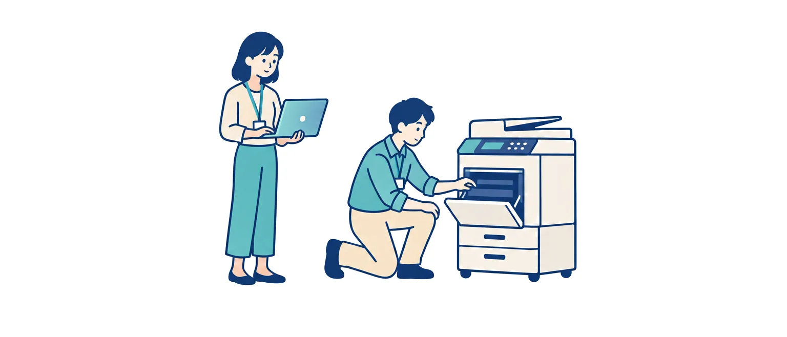 プリンターを確認する情シスの担当者と、ノートパソコンを持って待つ社員